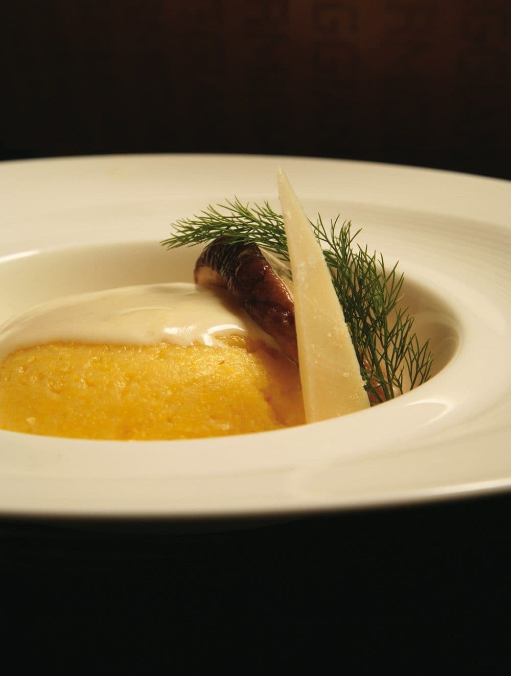 Polenta morbida con fonduta di Parmigiano Reggiano e funghi trifolati